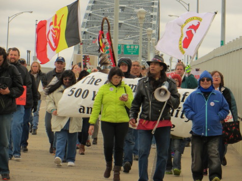 Protesters cross the Veteran’s Memorial Bridge en route to Progressive Field, home of the Cleveland Indians. The demonstrators finished their march at the stadium, carrying signs decrying the baseball team’s name and logo.