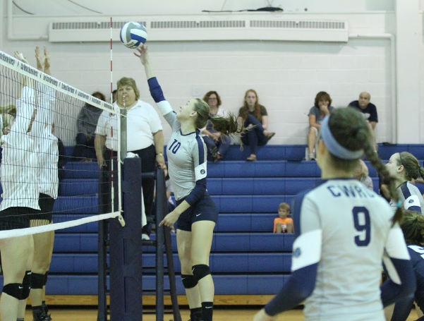 Attempting to clear two defenders, first-year Haley Sims tips the ball over the net. 
