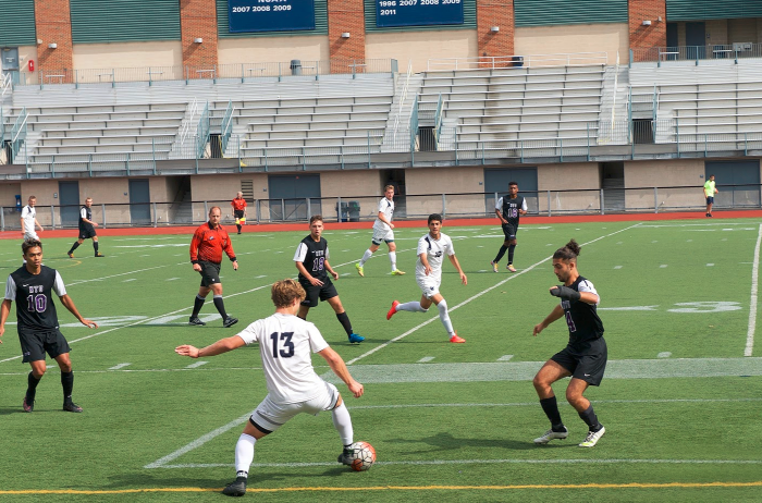Defenseman Alex Besl tries to dribble past a ring of NYU players during a match earlier this season. 