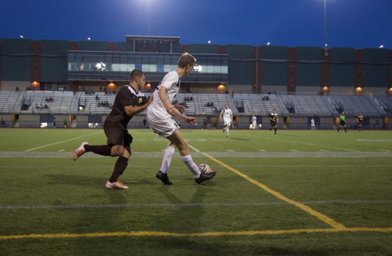 Second-year defender Christian Lytle tries to clear the ball as an opponent attacks him from behind. 
