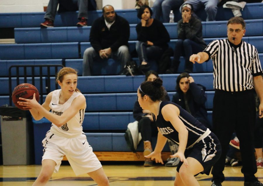 First-year+guard+Marissa+Muth+searches+for+a+teammate+past+a+Brandeis+defender.