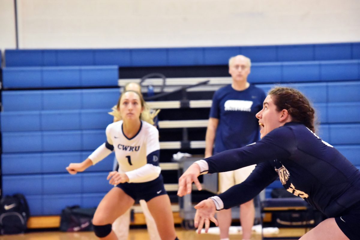 Noel Jeansonne frantically dives for the ball during the teams match against Baldwin Wallace; Haley Sims looks across the court after going up for a kill.