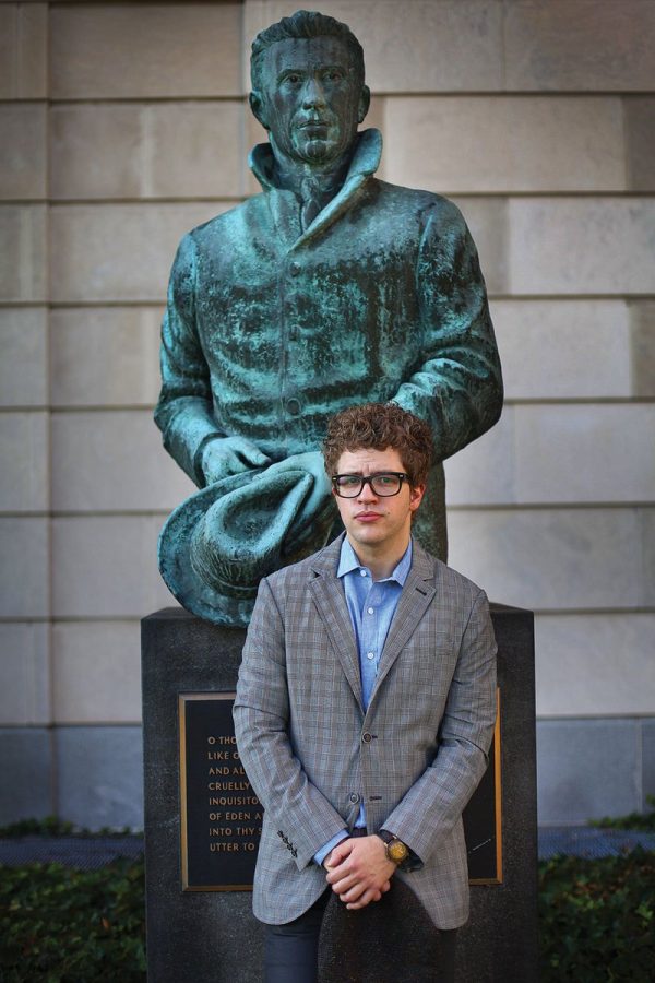 Dave Lucas standing with a statue of Cleveland poet Hart Crane behind the Kelvin Smith Library. The Poet Laureate cites this as one of his favorite spots on campus.