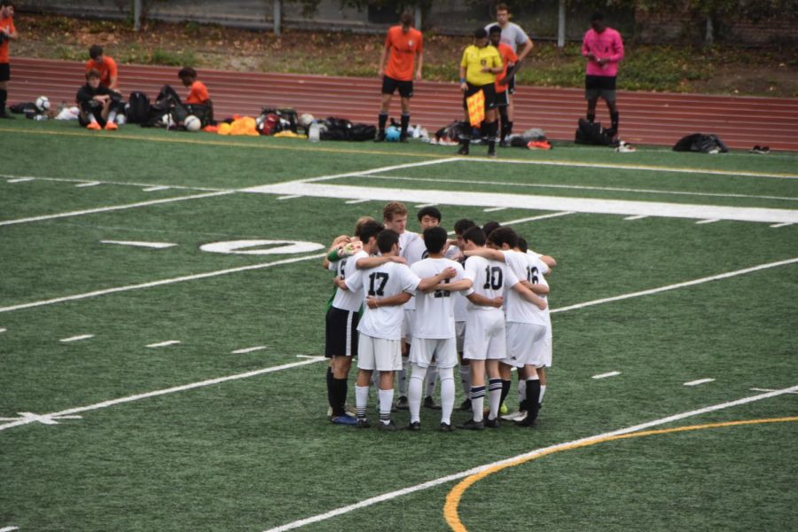 The club soccer team shows their tight bond and spirit by huddling for a pep and strategy talk. 