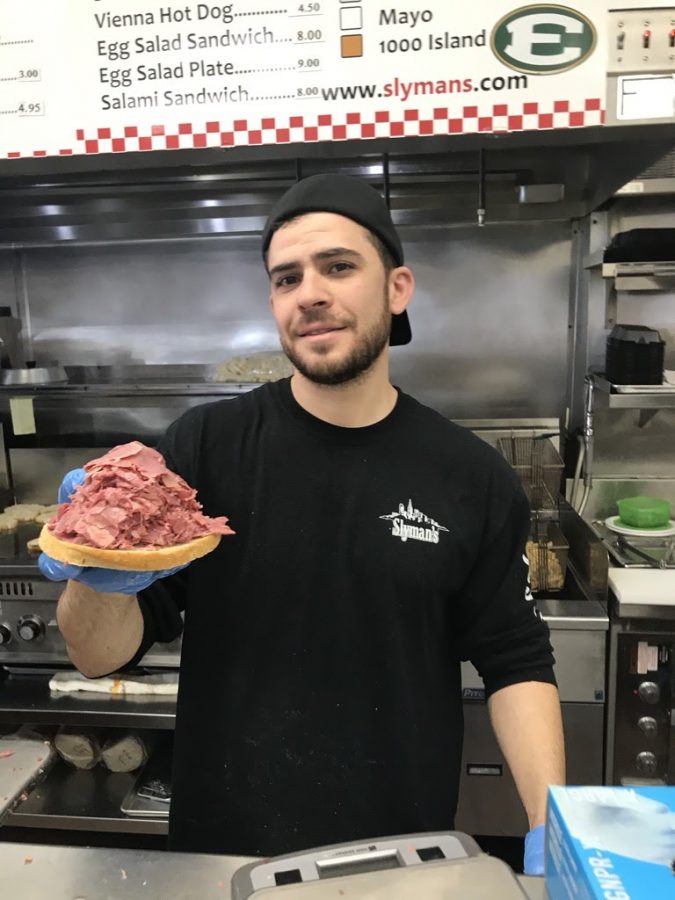 Slyman’s manager Sam Mahfouz holding up just one half of one corned beef sandwich. The restaurant sells between one and two thousand sandwiches a day.