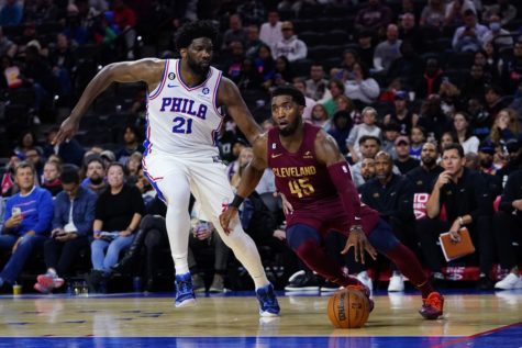 Cavs shooting guard Donovan Mitchell fends off 76ers Joel Embiid during a preseason game.