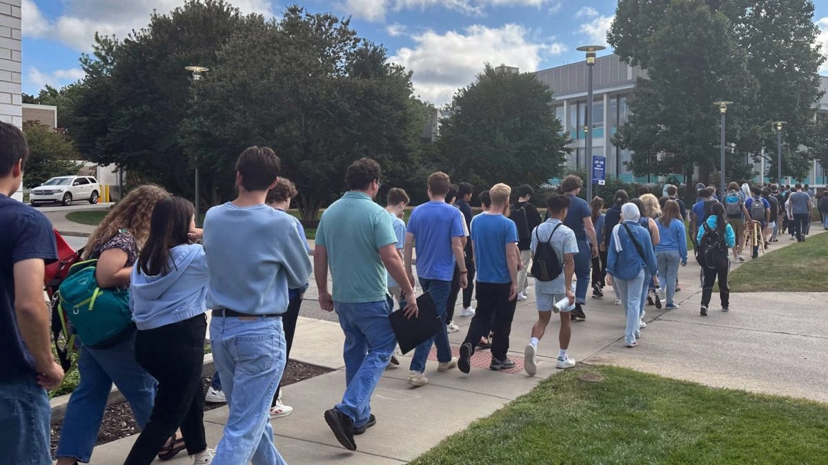 CIM+students+walk+together+to+Kulas+Hall+in+order+to+peacefully+protest+the+continued+employment+of+Principal+Conductor+Carlos+Kalmar%2C+wearing+blue+to+symbolize+unity.
