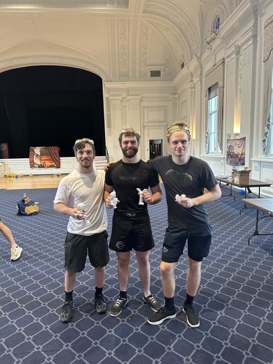(Left to right) Graduate student Mitchell Arch, fourth-year Walker Cox and second-year Daniel Passmore pose with their two laurel wreaths and miniature trophies after they placed top three in both wrestling and long jump.