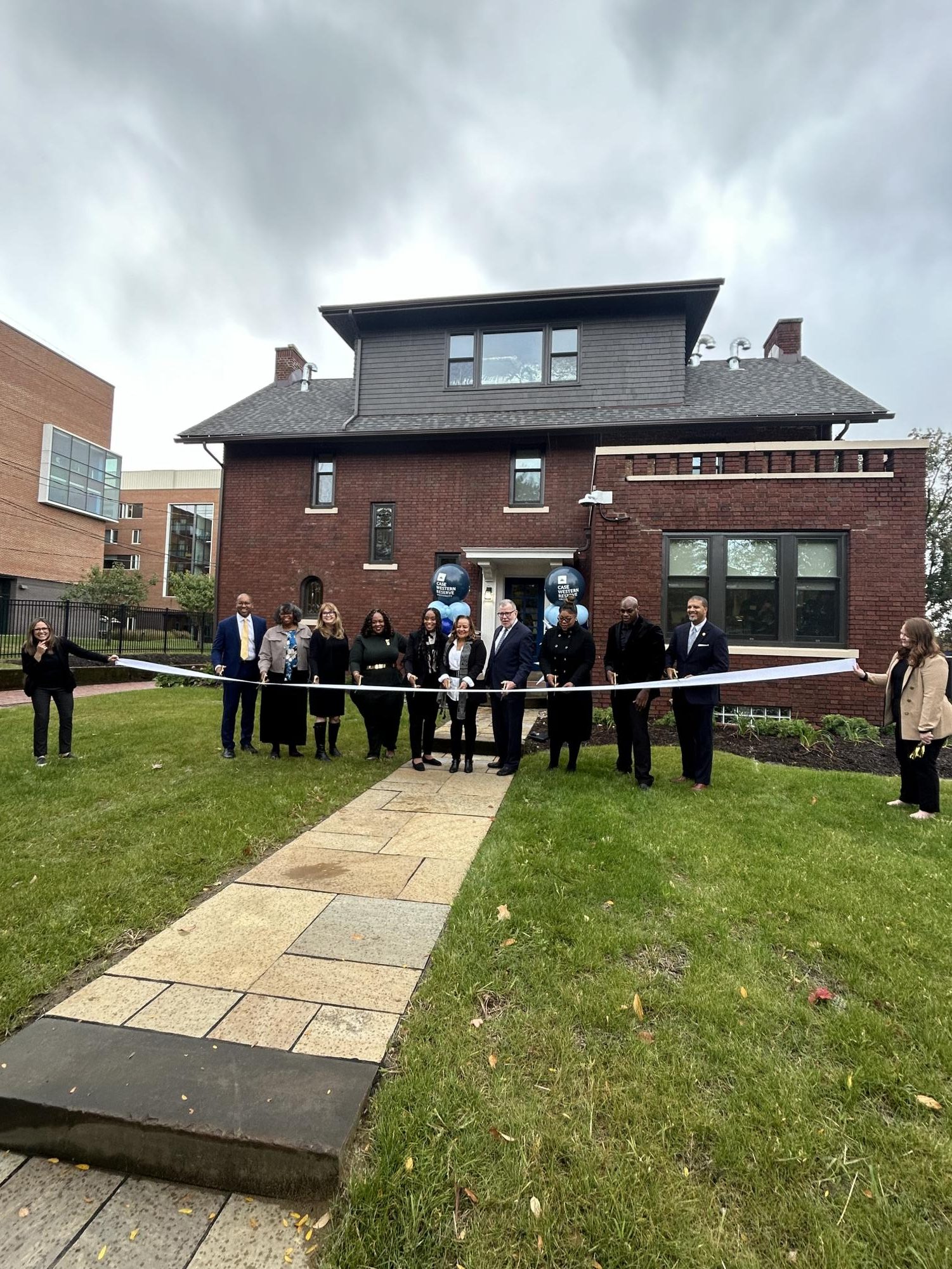 Local officials and community leaders gather in front of the newly opened Wade Park Community Engagement Center for the celebratory ribbon-cutting ceremony.